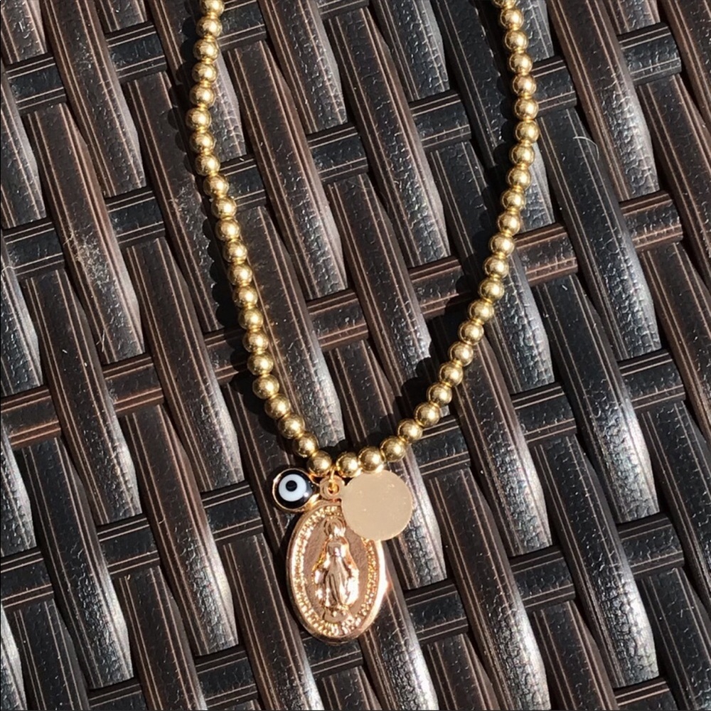Gold beaded bracelet with a pendant